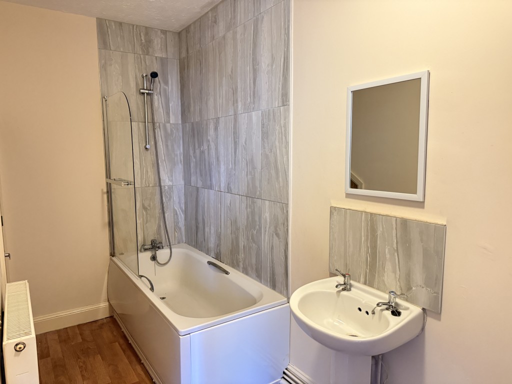 Lot: 119 - VACANT ONE-BEDROOM FLAT - Bathroom with white suite and tiles around bath